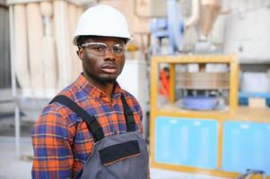 retrato de industrial ingeniero. fábrica trabajador en pie en fábrica producción línea foto