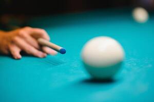 juego de billar el mano de un hombre con un de billar señal objetivos a un de billar pelota foto