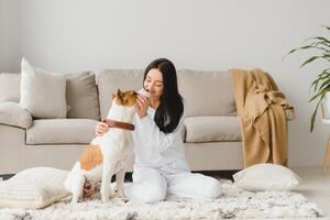 Young woman with her cute dog at home. Lovely pet. photo