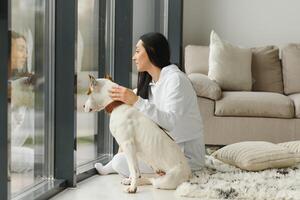 Young woman with her cute dog at home. Lovely pet. photo