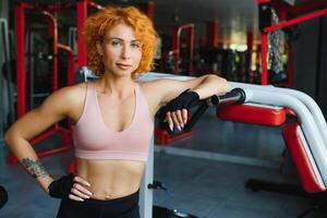 portrait of a sporty woman with red hair in the gym. photo