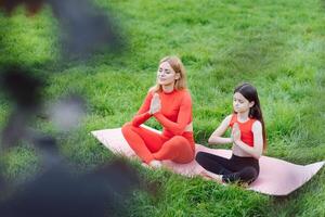 Mom and child in the lotus position on the nature photo