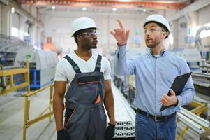 Two workers at a factory for the production of plastic windows. Engineer and worker on the production line photo