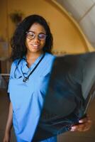 beautiful african american healthcare worker with x-ray, medical international concept, black doctor thinking, modern student photo