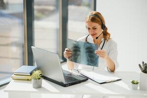 doctor talking with sick person through laptop online system and using mobile digital tablet computer searching patient medical records on the database files document photo