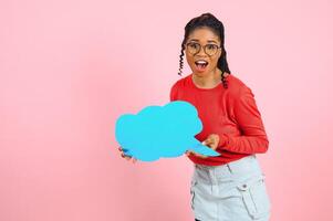 yo pensar. pensativo afro mujer mirando a blanco habla burbuja, conmovedor su mentón, espacio de copia, rosado estudio pared. foto