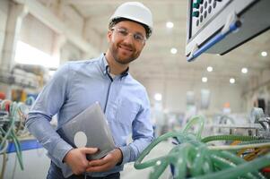 un joven masculino ingeniero inspecciona el producción de el plastico ventana marcos foto