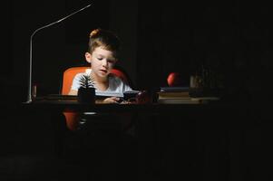 boy doing homework at home in evening photo