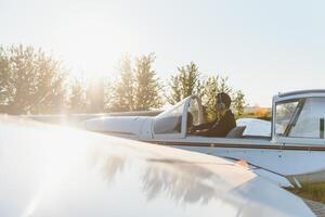 joven piloto se está preparando para despegar en avión privado. foto