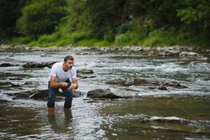 Bearded man catching fish. Summer leisure. Mature man fishing on the pond. Portrait of cheerful senior man fishing. Male fishing. Fishman crocheted spin into the river waiting big fish photo