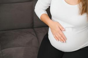 Image of pregnant woman touching her belly with hands photo