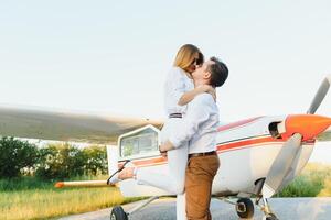 Couple in love hugging near private plane. Selective focus photo