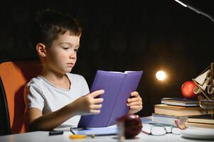 boy doing homework at home in evening photo