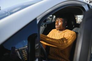 African American driving an electric car. photo