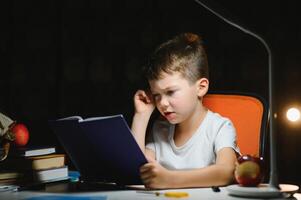 boy doing homework at home in evening photo