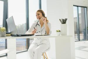 médico hablando con enfermo persona mediante ordenador portátil en línea sistema y utilizando móvil digital tableta computadora buscando paciente médico registros en el base de datos archivos documento foto