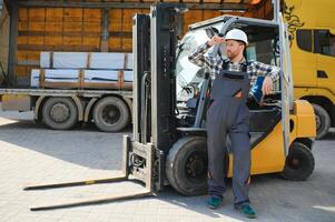 Portrait of professional forklift driver in factory's warehouse photo