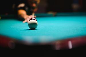 game of billiards the hand of a man with a billiard cue aims at a billiard ball photo