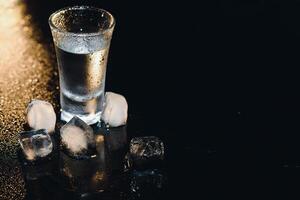 Vodka. Shots, glasses with vodka with ice .Dark background. Copy space .Selective focus. photo