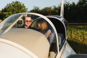 Young woman and pilot in in the cockpit of a plane. Front view photo