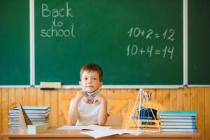 Schoolboy in the classroom in a protective mask. The concept of schooling during the epidemic photo