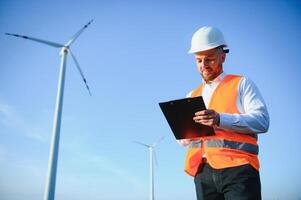 eléctrico ingenieros trabajando a viento turbina poder generador estación con ordenador portátil computadora foto