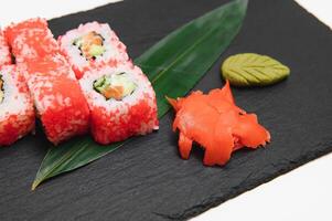 Japanese rolls on black background isolated with reflections photo