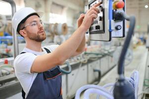 A male worker in a special uniform and an white helmet. Production of frames for PVC windows photo