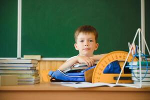 Education and learning. Little schoolboy in classroom. Schoolboy doing homework in classroom at school. Elementary school kid sitting at desk. Education. Kid at school. photo