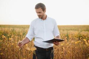 joven agricultor en campos de soja foto