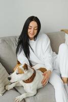 Young woman with her cute dog at home. Lovely pet. photo