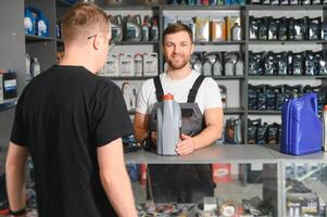 A customer speaks with a consultant at an auto parts store photo