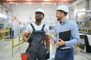 An engineer communicates with a worker on a production line photo