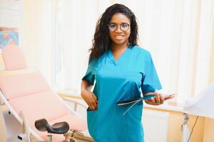 profesional hembra médico en borroso consultante habitación antecedentes. africano americano ginecólogo. ginecología concepto. foto