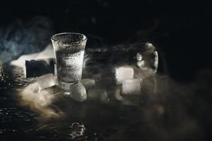 Vodka. Shots, glasses with vodka with ice .Dark background. Copy space .Selective focus. photo