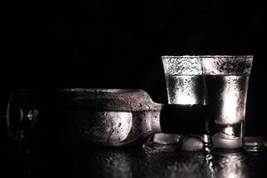 Vodka. Shots, glasses with vodka with ice .Dark background. Copy space .Selective focus. photo