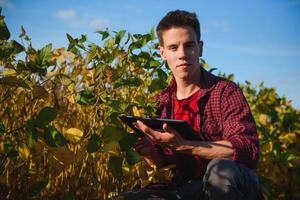 joven agricultor en campos de soja foto