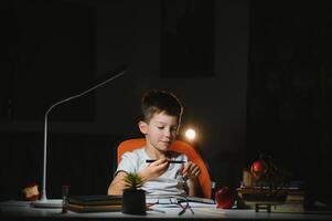 boy doing homework at home in evening photo