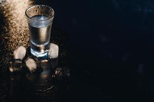 Vodka. Shots, glasses with vodka with ice .Dark background. Copy space .Selective focus. photo