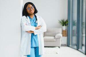 retrato de africano americano mujer médico sonriente en hospital. foto