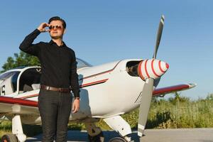 Business man with his airplanes. He is walking in the airport with the smart phone and making a call. photo