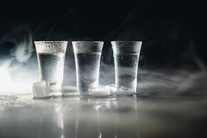 Vodka. Shots, glasses with vodka with ice .Dark background. Copy space .Selective focus. photo
