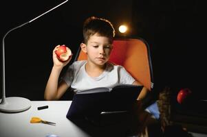 boy doing homework at home in evening photo