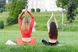 mujer y niño hacer yoga en el parque. verano, sol, madre y hija, salud. al aire libre Deportes. sano deporte estilo de vida. aptitud física, yoga foto