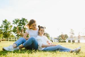 Lifestyle portrait mom and daughter in happines at the outside in the meadow photo