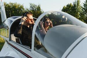 Young woman and pilot in in the cockpit of a plane. Front view photo