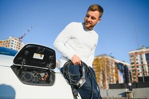 joven hombre cargando su coche foto