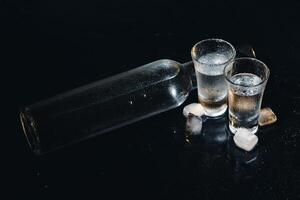 Vodka. Shots, glasses with vodka with ice .Dark background. Copy space .Selective focus. photo