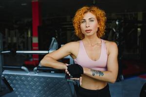 portrait of a sporty woman with red hair in the gym. photo