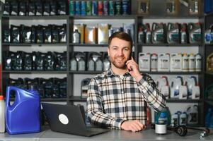 A salesman in an auto parts store. Retail trade of auto parts photo